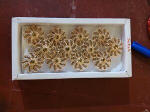 Gold floral finger ring with sparkling crystal stones arranged in an elegant rosette design