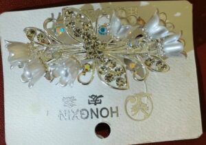 Silver floral hair clip with crystals and pearl petals for women.