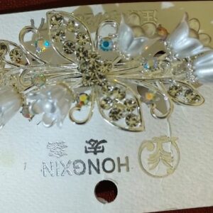 Silver floral hair clip with crystals and pearl petals for women.
